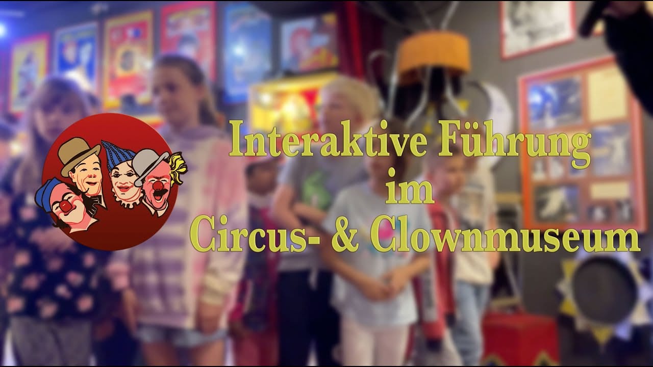 Four smiling girls holding a giant clown shoe over their heads during kindergarten and school guided tours at the Circus & Clown Museum Vienna.